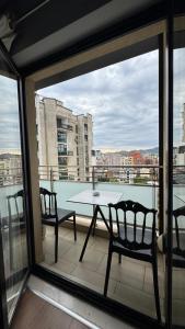Ein Tisch und Stühle auf einem Balkon mit Aussicht in der Unterkunft Your Cozy Stay - Tirana in Tirana