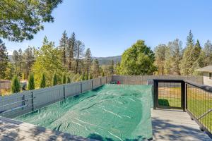 ein Swimmingpool mit einer grünen Plane auf einem Zaun in der Unterkunft Backyard Oasis with Hot Tub and Views Weaverville Gem in Weaverville