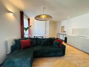 a living room with a green couch with red pillows at Hyper Centre Cathedral Boulingrin 201 in Reims