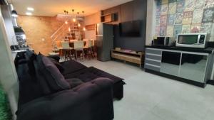 uma sala de estar com um sofá e uma cozinha em Casa c/ Churrasqueira a 550 m da Praia PDD0572 em Piçarras