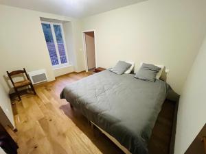 a bedroom with a bed with two pillows on it at Meublé Voltour dans la Villa Denise in Vals-les-Bains