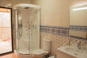 a bathroom with a shower and a toilet and a sink at Los Soportales-Casa historica siglo XVI a 20 minutos de Puy du Fou in Orgaz