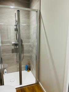 a shower with a glass door in a bathroom at Meublé Voltour dans la Villa Denise in Vals-les-Bains