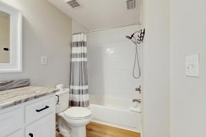un bagno bianco con wc e doccia di Coral Sunset a Fort Morgan Altre 11 foto