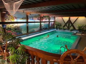 a large swimming pool with two people swimming in it at Haus Zellerwirt in Ruhpolding