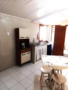 una pequeña cocina con mesa, mesa y sillas en Pe no Centro, en Porto Seguro