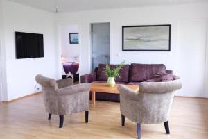a living room with a couch and two chairs and a table at Fagrahlid Guesthouse in Hvolsvöllur