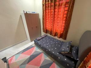 un petit lit dans une chambre avec une fenêtre dans l'établissement AM Homestay, à Kota Bharu 1 autre photo