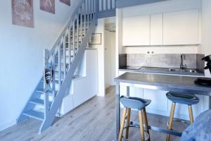 a kitchen with a counter and two stools at Maisonnette des Poissons, à 50 m de la mer in Pornic