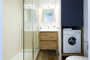 a bathroom with a washing machine and a sink at Maisonnette des Poissons, à 50 m de la mer in Pornic
