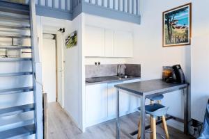 a small kitchen with a table in a tiny apartment at Maisonnette des Poissons, à 50 m de la mer in Pornic