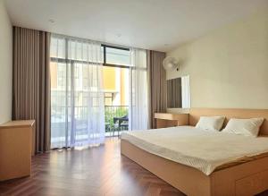 une chambre avec un grand lit et une grande fenêtre dans l'établissement Cozy homestay, à Cửu Cảo