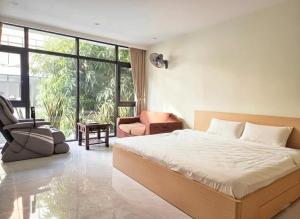 - une chambre avec un lit, une chaise et une fenêtre dans l'établissement Cozy homestay, à Cửu Cảo