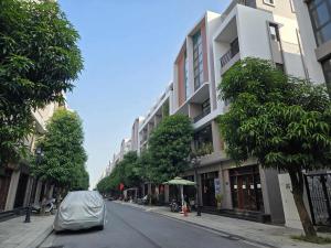 une voiture garée sur le bord d'une rue à côté d'un bâtiment dans l'établissement Cozy homestay, à Cửu Cảo