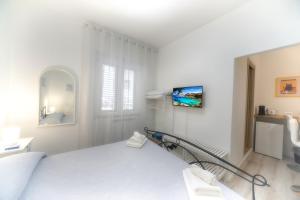 Un dormitorio blanco con una cama y una escalera. en Margherita Guest House, en Olbia