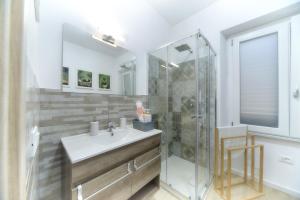 un baño con lavabo y ducha en Margherita Guest House, en Olbia
