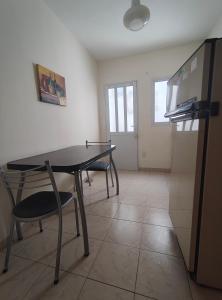 a kitchen with a table and two chairs and a refrigerator at Departamento Peña in Carhué