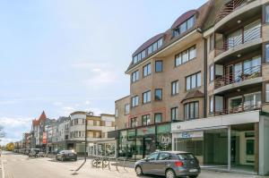 una calle con coches estacionados frente a los edificios en Hera 0101, en Koksijde