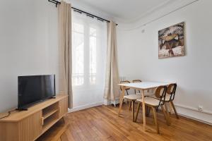 シュレーヌにある3P Cocooning prés Paris La Défense Champs Élyséesのテーブルとテレビのあるリビングルーム