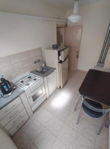 a small kitchen with a stove and a refrigerator at Departamento Peña in Carhué