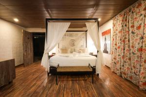 una camera da letto con un letto bianco con baldacchino di Nanau Resort & Spa a Ramnagar Altre 37 foto