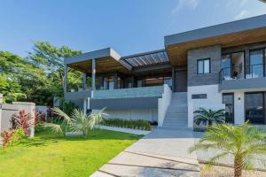 a modern house with a balcony and a yard at Beach Mode Luxury 3-Story House in Tamarindo in Tamarindo