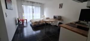 a room with a bed and a kitchen with a table at Dampierre Studio 300 m du CNPE in Dampierre-en-Burly +3 photos