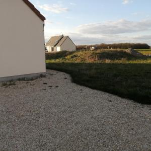 a gravel road next to a house and a field at Dampierre Studio 300 m du CNPE in Dampierre-en-Burly