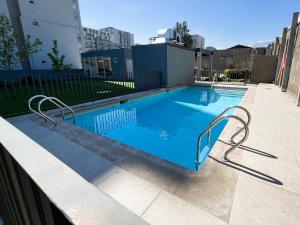 ein Swimmingpool mit blauem Wasser in einem Gebäude in der Unterkunft Apartamento en Ñuñoa, estacionamiento, Estadio Nacional, Piscina in Santiago