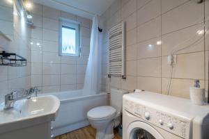 a bathroom with a toilet sink and a washing machine at Zakątki Świata in Poznań