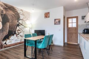 a dining room with a table and chairs and an elephant mural at Zakątki Świata in Poznań +44 photos