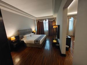 ラス・アル・ハイマにあるSunday Mangrove Corniche Hotel, Ras Al Khaimahのベッド1台と窓2つが備わるホテルルームです。