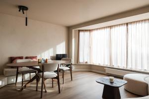 a living room with a table and chairs and a couch at Ruim, stijlvol gerenoveerd vakantieappartement voor 4 personen vlak bij zee en de duinen in De Panne