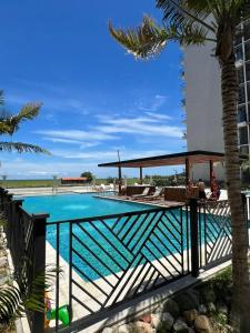 a swimming pool at a resort with a palm tree at Apartamento en Salinas Del Mar, a 10 min de la playa in Gaira