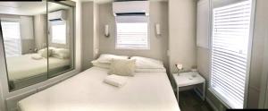 a small room with a bed and a mirror at Waterfront Tiny Home Pool Dock Kayaks Paddleboards in Key Largo +49 photos