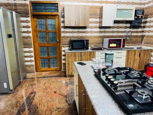 a kitchen with a stove and a counter top at LUXE Penthouse 4BHK with Swimming pool in Mysore