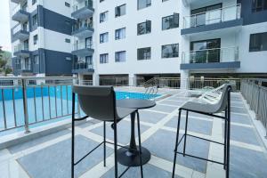 a balcony with a table and chairs and a swimming pool at Orchid Residency, Westlands in Nairobi