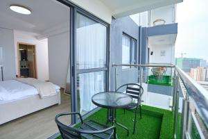 a balcony with a bed and a table and chairs at Orchid Residency, Westlands in Nairobi +230 photos