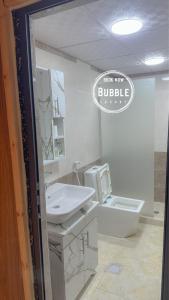a white bathroom with a sink and a toilet at BUBBLES LUXURY CAMp & BUBBLES ROOM in Disah