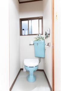 a bathroom with a blue toilet and a window at Ao by Perch Japan in Nagoya +17 photos