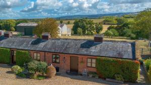 an old red brick house with a large roof at Cotton Farm Estate - 4 Cottages Sleeps 16 in Aston Somerville +23 photos