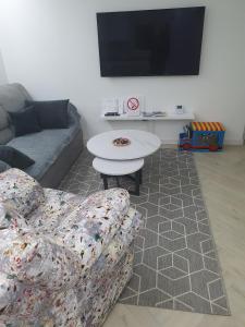 a living room with a couch and a table and a tv at Green Home Bihać in Bihać