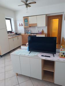 a kitchen with white cabinets and a ceiling fan at Appartamento la Madonnina in Besenello