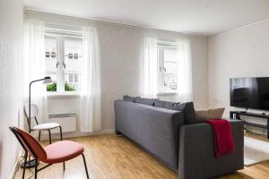 a living room with a gray couch and a tv at Relax in peaceful and sunny Marmaverken apartment 