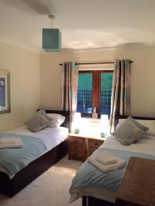 1 Schlafzimmer mit 2 Betten und einem Fenster in der Unterkunft Cottage at the Hollow in North Middleton