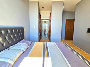 ein großes Bett in einem Zimmer mit blauen Wänden in der Unterkunft Departamento de dos dormitorios en el Corazón de Santa Cruz in Santa Cruz de la Sierra