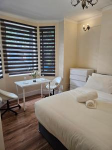 Un dormitorio con una cama y una mesa y sillas. en Peacock Quarters, en Croydon