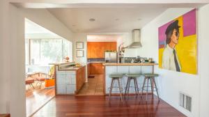 a kitchen with bar stools and a painting on the wall at Silver Lake Mid-century Nestled In The Treetops in Los Angeles