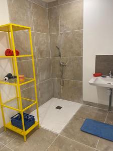a shower with a yellow shelf in a bathroom at Le pop Daudet in Fontvieille
