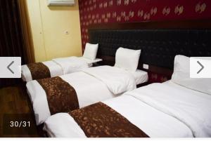 a group of three beds in a hotel room at فندق برستيج العقبه Prestig in Aqaba
